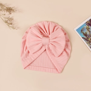 Detail of pink jacquard knit baby turban hat with soft ribbed texture and large bow