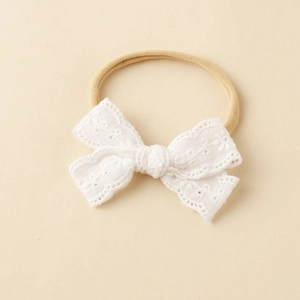 Detail von Baby-Haarband mit weißer Spitzenschleife und weichem Nylon-Stirnband