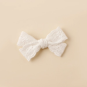 Macro view of white lace butterfly hair clip showing intricate floral embroidery detail