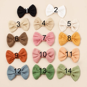 Flat lay of 14-piece colorful cotton bow hair clips in various Morandi tones
