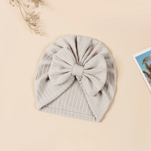 Detail of baby beige knot beanie with soft ribbed texture and large decorative bow