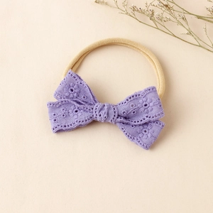 Detail eines Baby Spitzen Stirnbandes mit lila Blumenstickerei und elastischem Nylonband