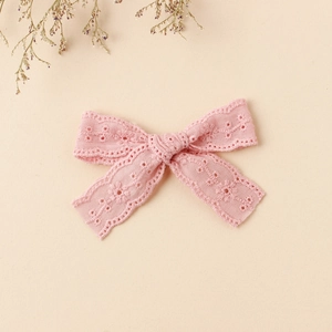 Close-up of pink lace embroidery bow hairpin with delicate floral pattern for girls
