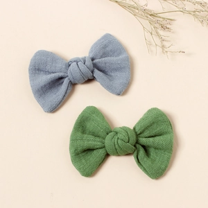 Two textured fabric bow hair clips for girls in blue and green colors for daily wear