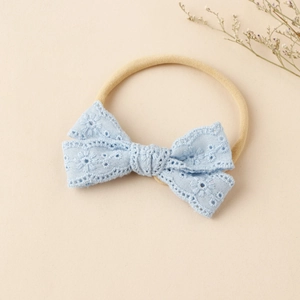 Detail eines Baby Stirnbandes mit hellblauer Spitzenschleife und elastischem Nylonband