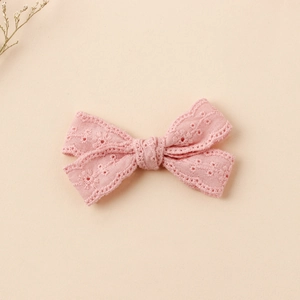 Detail of pink embroidered lace bow hair clip for girls with floral hollow patterns