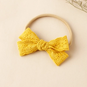 Detail eines gelben Spitzen-Stirnbands mit Blumenstickerei auf weichem Nylonband