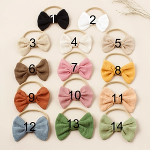 Set of 14 colorful nylon baby headbands with textured soft fabric bows in various pastel shades