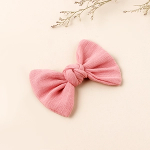 Detail of pink waffle knit bow hair clip showcasing the soft fabric texture and weave