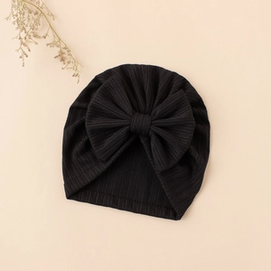 Detailed view of black ribbed knit baby turban hat featuring a large decorative bow tie