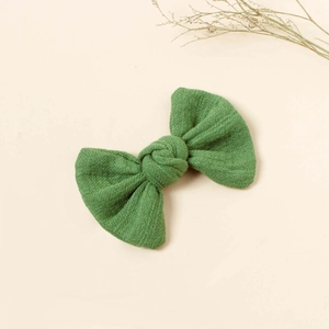 Detail view of the green fabric bow hair clip with textured weave for girls