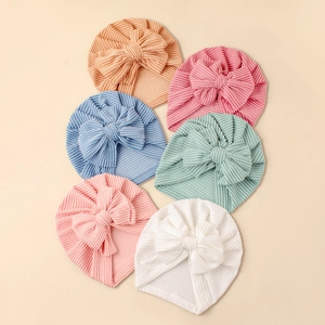 Close-up of six soft striped baby turban hats with oversized bows in various pastel colors