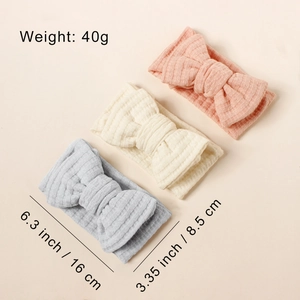 Detailed view of elastic waffle fabric baby bow headbands in pink, cream, and blue set
