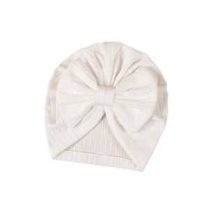 White jacquard knit baby beanie featuring a large decorative bow on elastic ribbed fabric