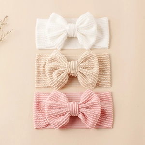 Lot de trois bandeaux bébé à nœud en blanc, beige et rose avec texture élastique côtelée