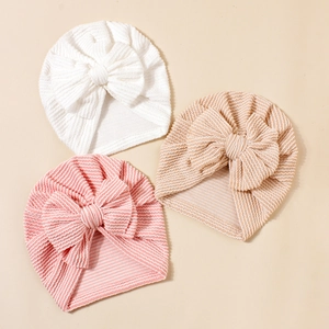 Three striped and white baby turbans with large bows in soft knit fabric textures