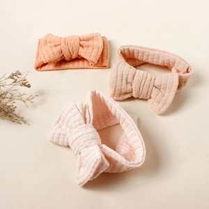 Three-piece set of waffle knit baby headbands with large double-layered bows in pastel colors