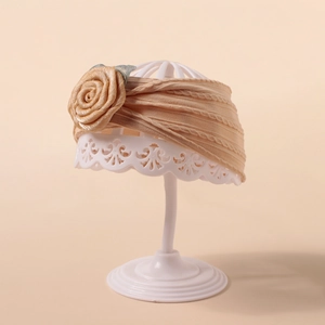 Detailansicht des beigen Baby-Stirnbands mit großer Seidenrose und Strickmuster-Textur