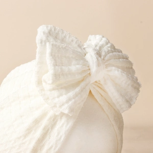 Bonnet turban blanc en maille gaufrée pour bébé avec un grand nœud souple pour nourrissons