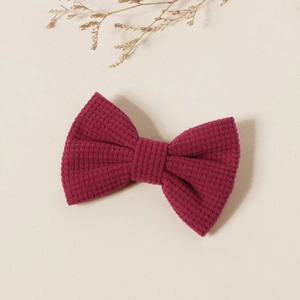 Détail d'une pince à cheveux nœud papillon bordeaux avec texture en relief