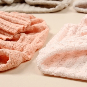 Gros plan sur la maille gaufrée douce et la texture des bonnets roses pour bébés