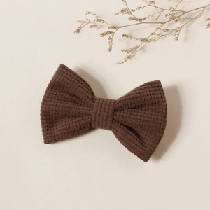 Détail d'un nœud papillon en velours côtelé marron foncé avec une texture à rayures