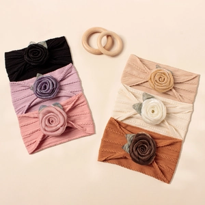 Detailansicht von sechs Jacquard-Nylon-Baby-Stirnbändern mit Rosenblüten in verschiedenen Farben