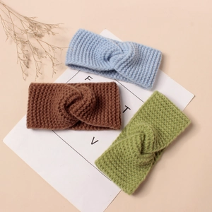 Détail de bandeaux torsadés en maille bleu ciel, marron et vert avec texture côtelée
