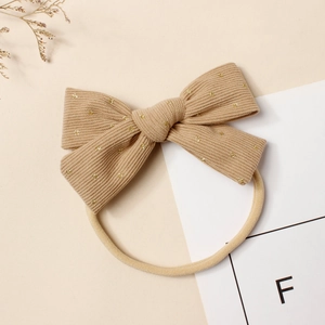 Détail du bandeau bébé en velours beige à pois dorés avec bande élastique en nylon