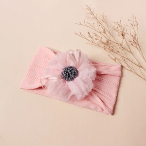 Close-up of pink jacquard nylon baby headband with delicate lace mesh flower detail