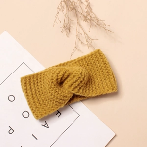 Gros plan du bandeau tricoté jaune gingembre pour enfants avec nœud torsadé