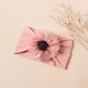 Detail of baby headband with pink jacquard nylon fabric and 3D mesh floral decoration