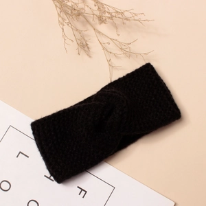 Détail d'un bandeau en tricot noir avec nœud torsadé et texture douce et chaleureuse