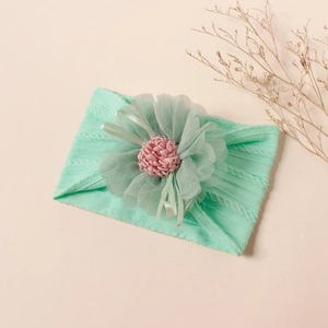 Detailed macro view of mint green ribbed nylon baby headband with a large mesh flower accent
