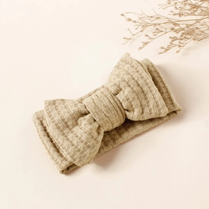 Detailed macro view of waffle knit baby headband with elegant double-layered bow design