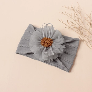 Detail of grey knitted baby headband with large mesh flower and crochet center decoration