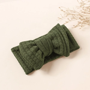 Detailed shot of dark green waffle texture fabric and a large bow on child headband