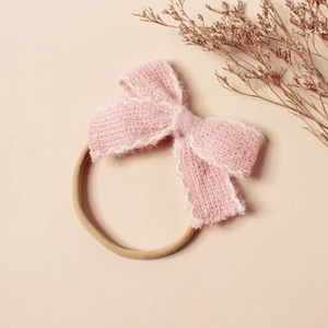 Détail du bandeau à nœud en peluche tricoté rose avec bande en nylon élastique pour bébés