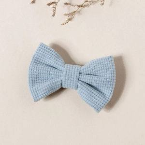 Gros plan détaillé d'une barrette à cheveux nœud bleu clair avec texture nid d'abeille