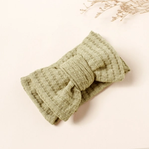 Detail view of olive green waffle knit baby headband with a soft double bow design