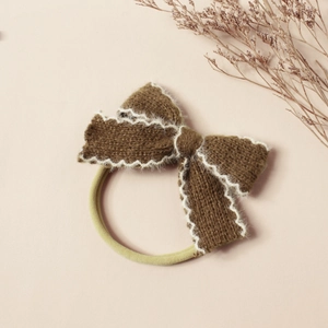 Détail du nœud tricoté marron foncé avec bord blanc et bandeau en nylon élastique souple
