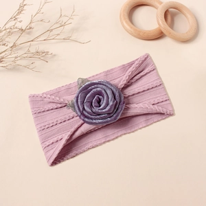 Nahaufnahme vom lila gestrickten Baby Stirnband mit Metallic Rose und silbernem Netzblatt