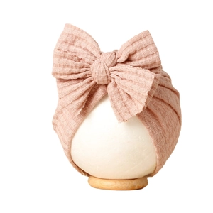 Bonnet turban rose en tricot gaufré pour bébé avec un grand nœud décoratif