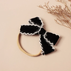 Détail d'un bandeau en tricot noir avec bords en peluche blanche et bande nylon élastique