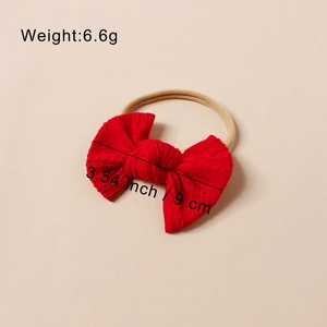 Detailansicht eines roten Strick-Stirnbands mit Schleife, 9 cm Größe und Zopfmuster