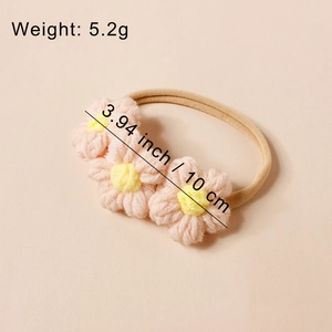 Dettaglio di tre fiori in maglia rosa su una fascia elastica in nylon beige per bambine