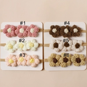 Dettaglio di sei fasce in nylon con fiori fatti a mano all'uncinetto per neonati in colori assortiti