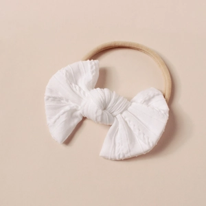 Detailansicht der weichen weißen Jacquard-Schleife am hochelastischen Baby-Stirnband