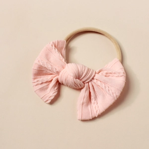Detail eines rosa Zopfstrick-Stirnbands für Babys mit elastischem Nylon-Band