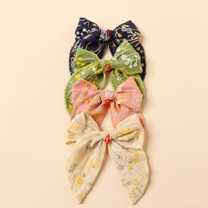 Embroidered floral bow hair clips in four pastel colors with long ribbon tails